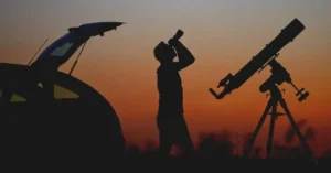 A man holding a biocular for sky observation.