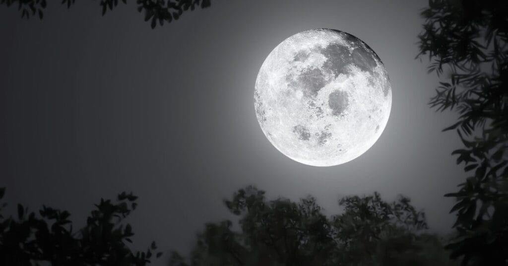 A close-up of a full moon, its surface illuminated by the sun