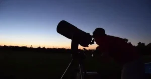 A Man using a telescope during the day Day Time astronomy