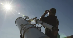 A man covering his eyes after using telescope